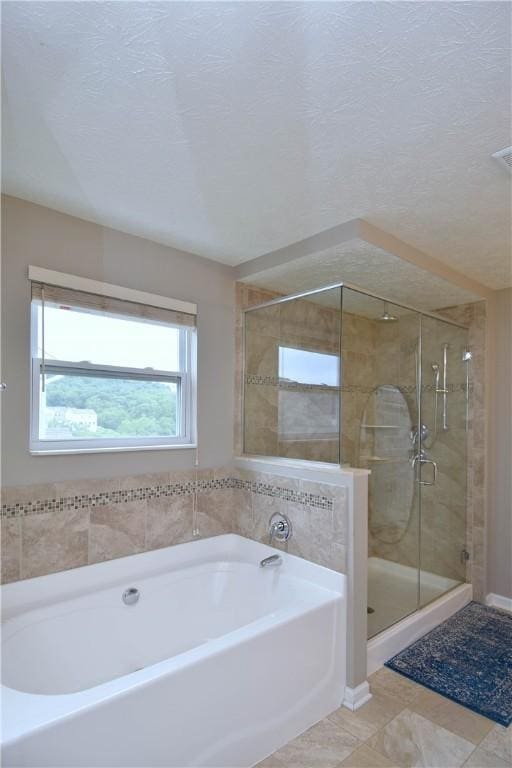 bathroom with tile patterned flooring, a textured ceiling, and independent shower and bath