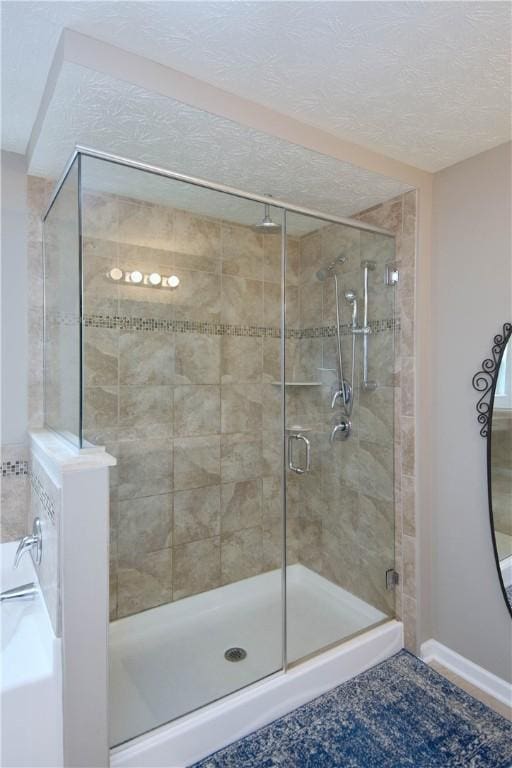 bathroom featuring tile patterned floors, a shower with shower door, and a textured ceiling