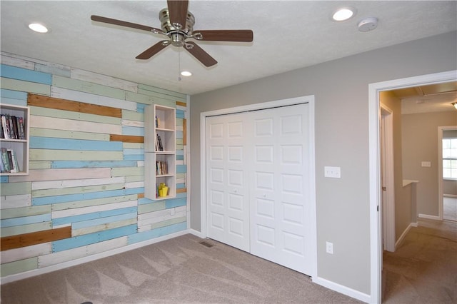 unfurnished bedroom with a closet, ceiling fan, and light colored carpet