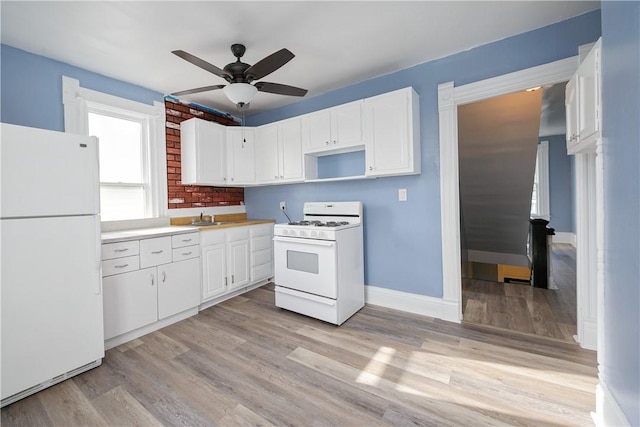 kitchen featuring white cabinets, white appliances, and light hardwood / wood-style floors