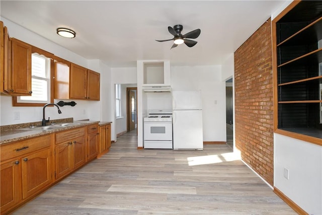 kitchen featuring white appliances, sink, ceiling fan, light hardwood / wood-style floors, and brick wall