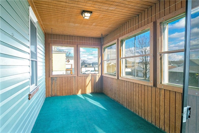 unfurnished sunroom with plenty of natural light and wooden ceiling