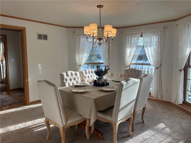 dining space with a notable chandelier, ornamental molding, and a wealth of natural light