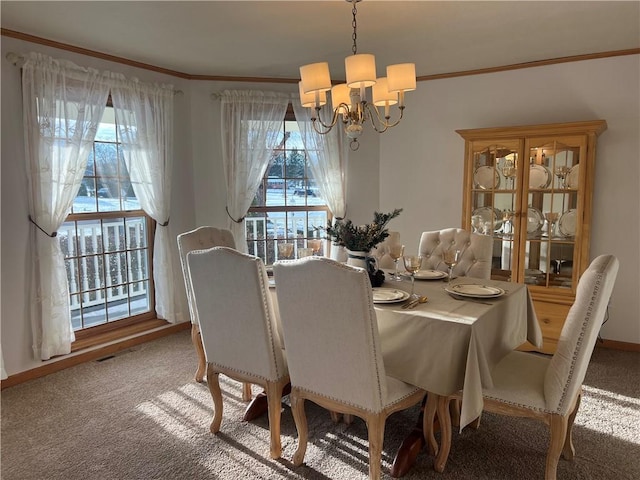 carpeted dining room with a chandelier and crown molding