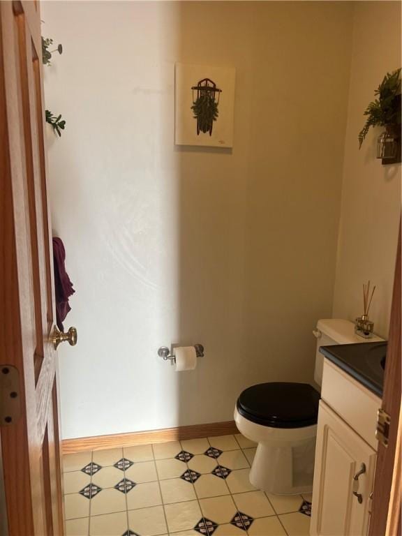 bathroom with tile patterned flooring, vanity, and toilet