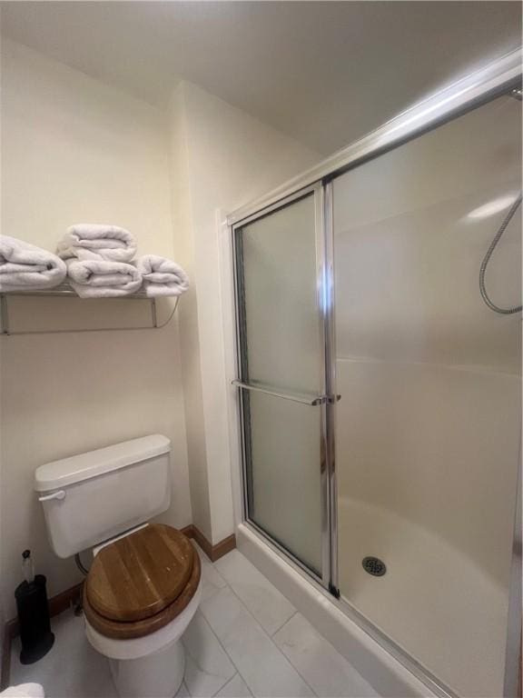 bathroom with a shower with shower door and toilet