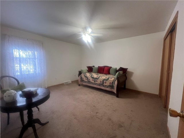 carpeted bedroom with a closet, visible vents, and a ceiling fan