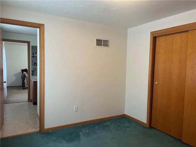 unfurnished bedroom featuring baseboards, visible vents, a closet, and carpet