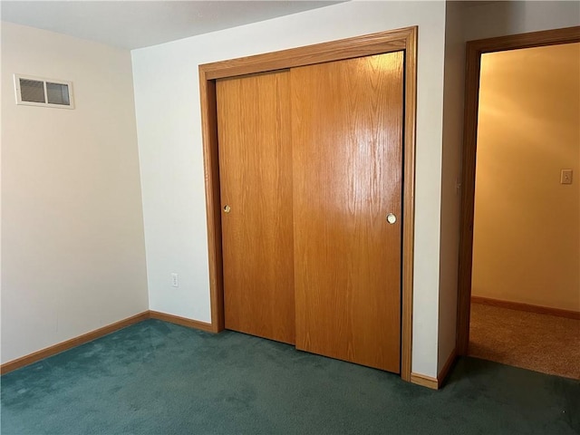 unfurnished bedroom featuring carpet flooring, baseboards, a closet, and visible vents