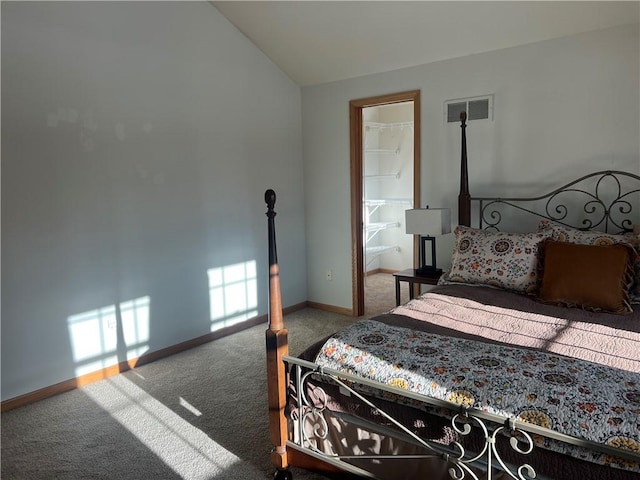 carpeted bedroom featuring baseboards, vaulted ceiling, and visible vents