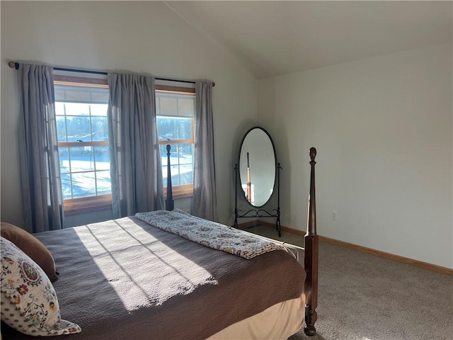 carpeted bedroom with baseboards and lofted ceiling