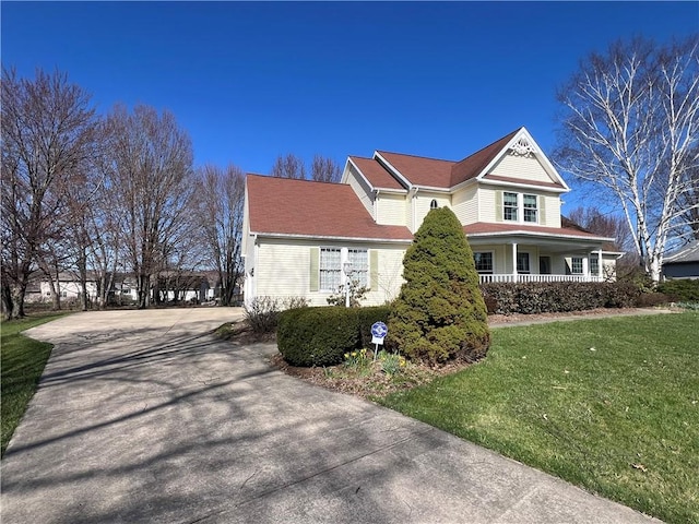 view of property exterior featuring concrete driveway, a porch, and a yard