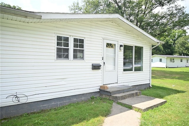 doorway to property featuring a yard