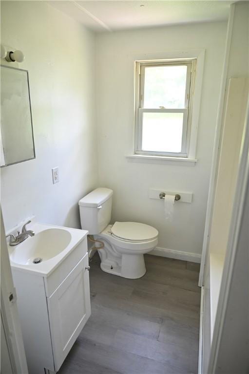 bathroom with wood-type flooring, vanity, and toilet