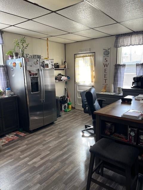 office space featuring a paneled ceiling, plenty of natural light, and hardwood / wood-style flooring