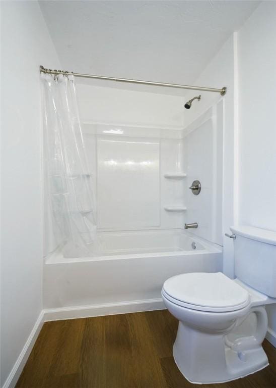 bathroom with hardwood / wood-style floors, toilet, and shower / bath combination with curtain