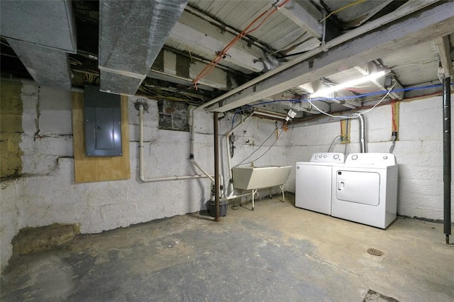 basement featuring sink, electric panel, and washing machine and clothes dryer