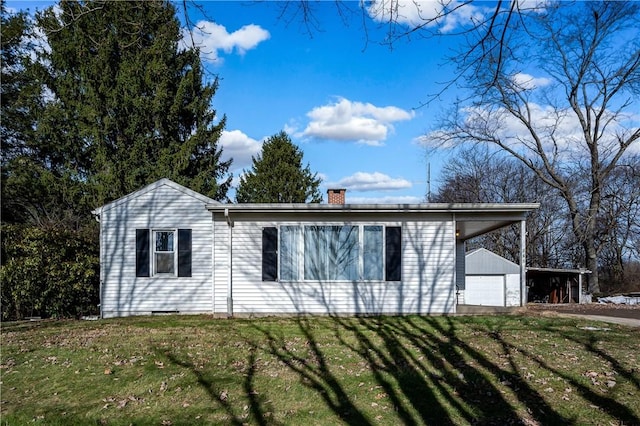 view of home's exterior featuring a yard, a garage, and an outdoor structure