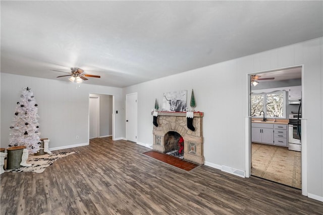 living room with a fireplace, dark hardwood / wood-style flooring, and sink