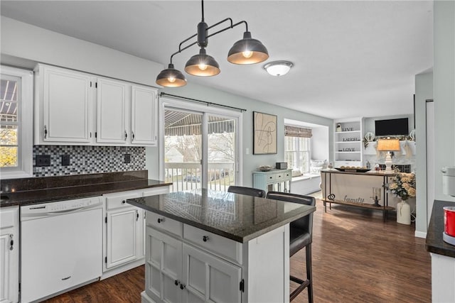 kitchen featuring dishwasher, hanging light fixtures, dark wood-type flooring, a breakfast bar, and white cabinets