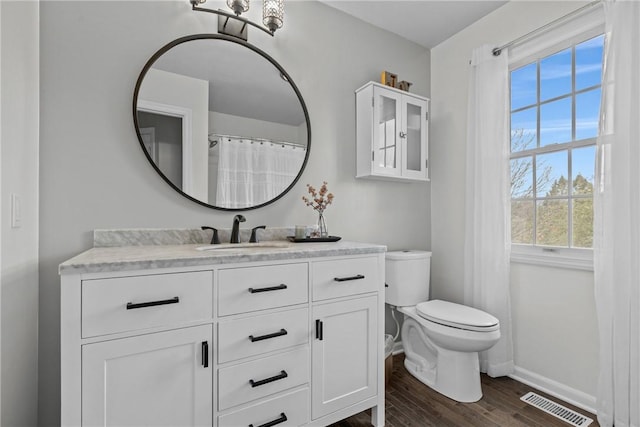 bathroom with toilet, vanity, and hardwood / wood-style flooring