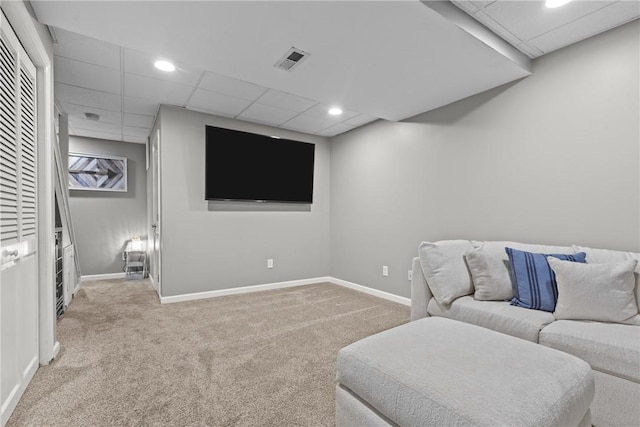 living room with a paneled ceiling and light carpet