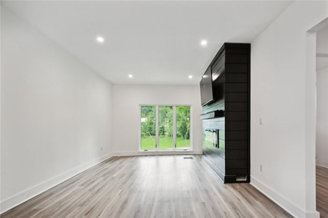 unfurnished living room with light hardwood / wood-style floors and a fireplace