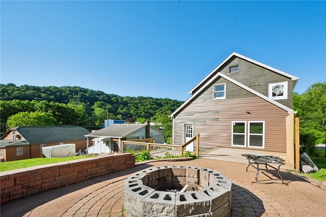 rear view of house with a patio and an outdoor fire pit