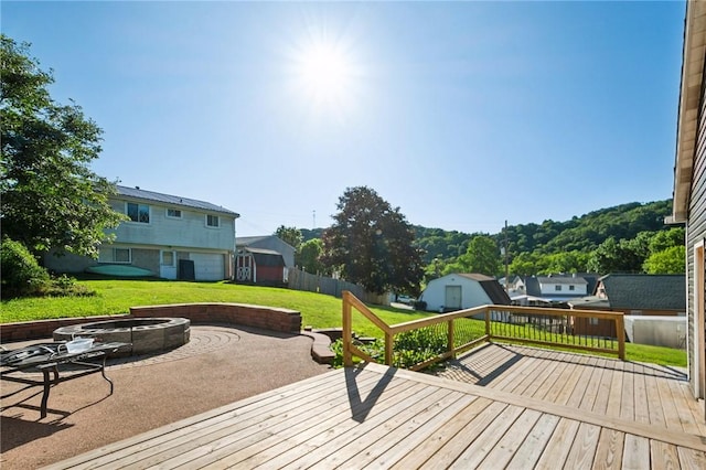 wooden deck featuring a lawn and an outdoor fire pit