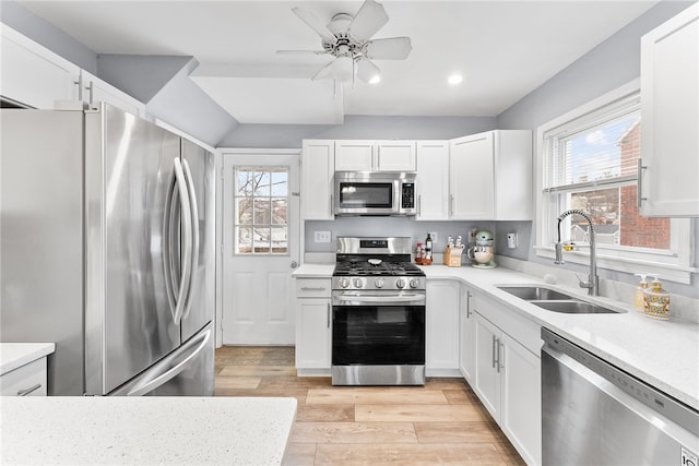 kitchen with light wood-type flooring, white cabinetry, sink, and appliances with stainless steel finishes