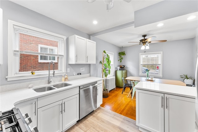 kitchen with sink, white cabinets, stainless steel dishwasher, and light hardwood / wood-style floors