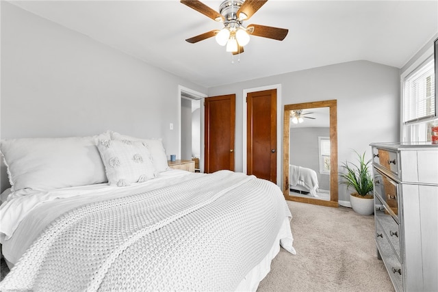 carpeted bedroom with multiple closets, ceiling fan, and lofted ceiling