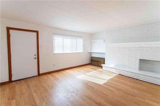 unfurnished living room with light wood-type flooring and radiator heating unit