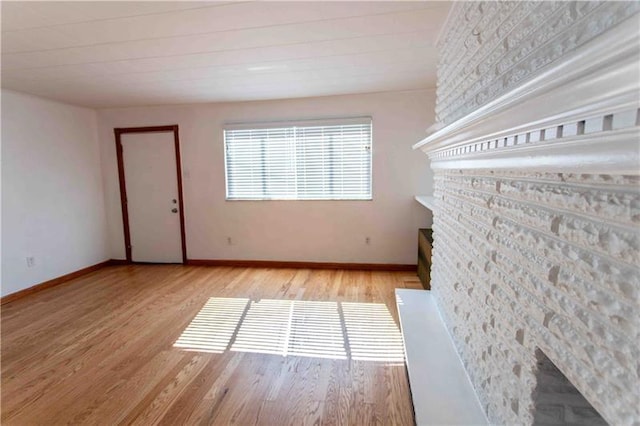 unfurnished room with a fireplace and light wood-type flooring