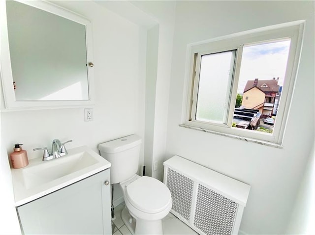 bathroom featuring tile patterned flooring, vanity, toilet, and radiator heating unit