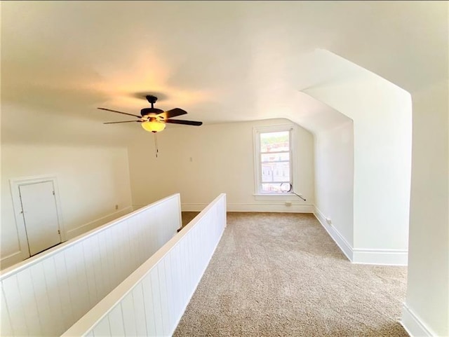 corridor with light carpet and vaulted ceiling