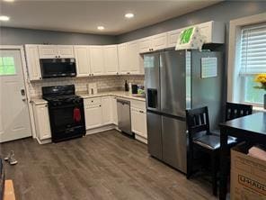 kitchen with black appliances, decorative backsplash, white cabinetry, and dark wood-type flooring