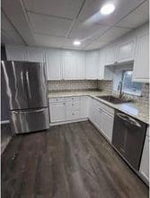 kitchen featuring white cabinets, appliances with stainless steel finishes, and dark hardwood / wood-style floors