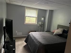 bedroom with a paneled ceiling and carpet