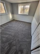 empty room featuring dark colored carpet and plenty of natural light