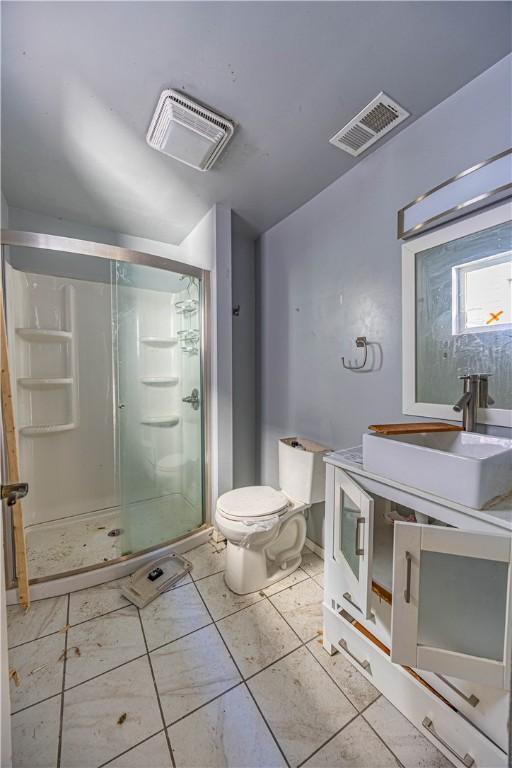 bathroom featuring toilet, an enclosed shower, and sink