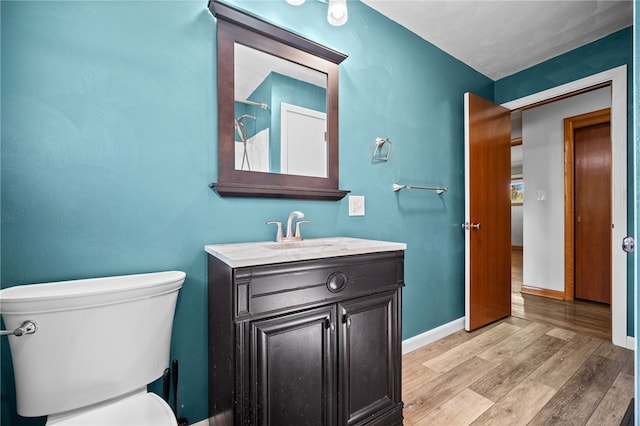 bathroom featuring toilet, vanity, and hardwood / wood-style flooring