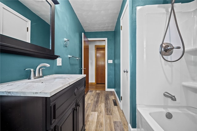 bathroom featuring washtub / shower combination, vanity, and hardwood / wood-style flooring