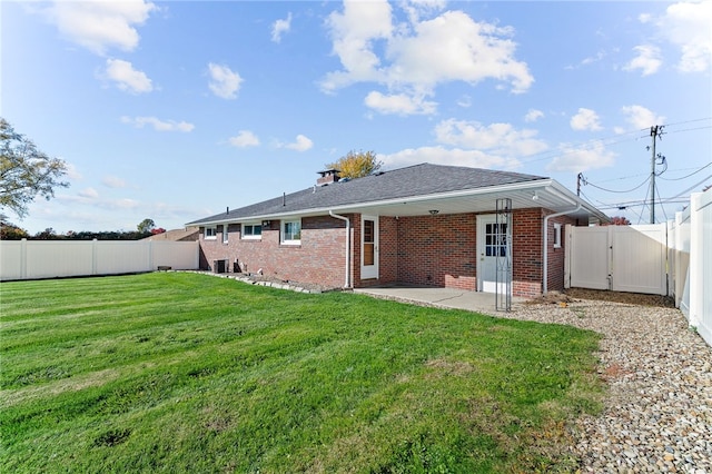 back of house with a yard and a patio area