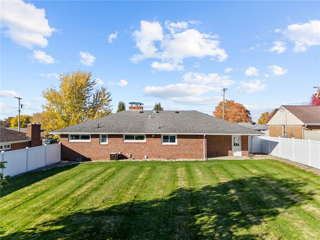 back of house with a lawn and central air condition unit