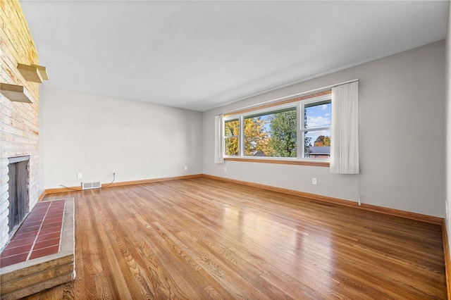 unfurnished living room featuring a fireplace and wood-type flooring