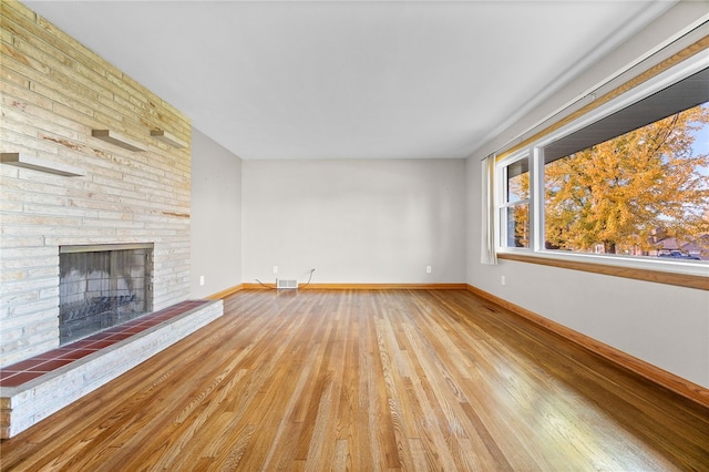 unfurnished living room featuring a fireplace and light hardwood / wood-style flooring