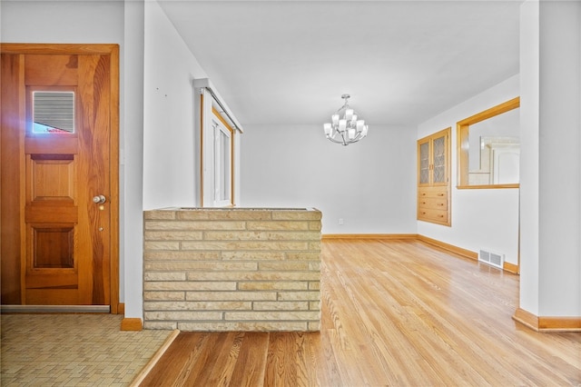 entryway with hardwood / wood-style floors and an inviting chandelier