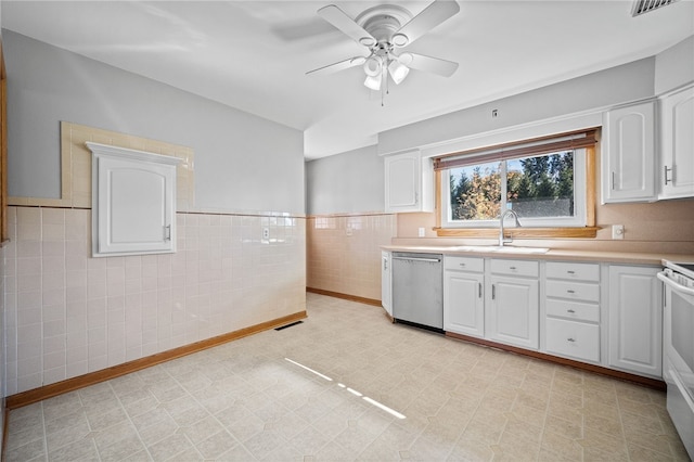 kitchen featuring ceiling fan, sink, tile walls, dishwasher, and white cabinetry