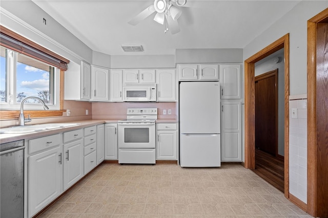 kitchen with white cabinetry, sink, ceiling fan, and white appliances